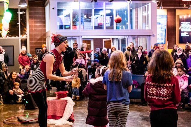 A circus performer entertaining children with a juggling act during the festival