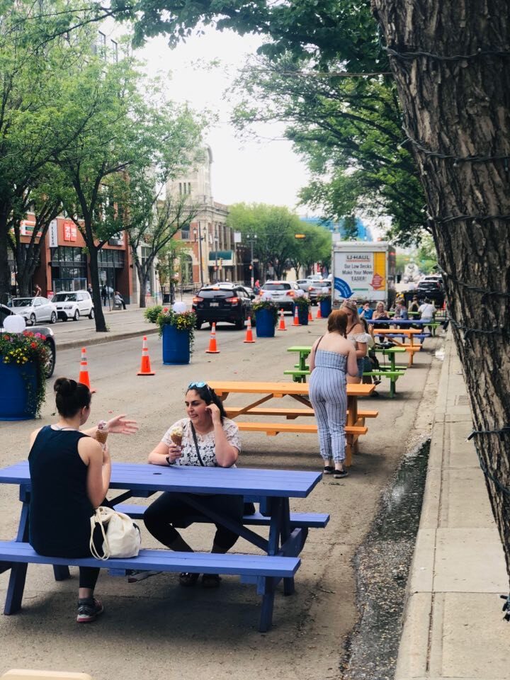 Temporary curbside seating and planters added to Whyte Avenue to expand pedestrian space